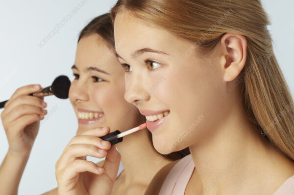 Teenage girls applying makeup
